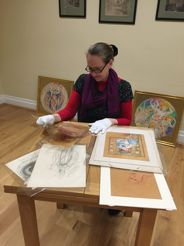 Vivienne Roberts, curator, examines artwork as she prepares for the exhibition. 